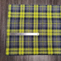Le tissu en flanelle à carreaux colorés de Longon Craft France, ultra-douillet pour l'automne, est présenté sur bois sombre avec une règle en centimètres indiquant l'échelle. Idéal pour des vêtements chauds, vendu au mètre.