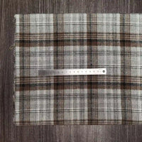 A folded Tissu en flanelle à carreaux colorés Longon Craft France, ultra-douillette polyester-coton pour l'automne, repose sur un bois sombre avec une règle métallique de 20 cm posée dessus, parfait pour vêtements d'hiver.