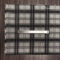 Un morceau de tissu en flanelle à carreaux colorés au mètre, polyester-coton ultra-douillet pour l'automne, de Longon Craft France, est présenté sur du bois avec une règle métallique de 20 cm placée horizontalement pour l'échelle.