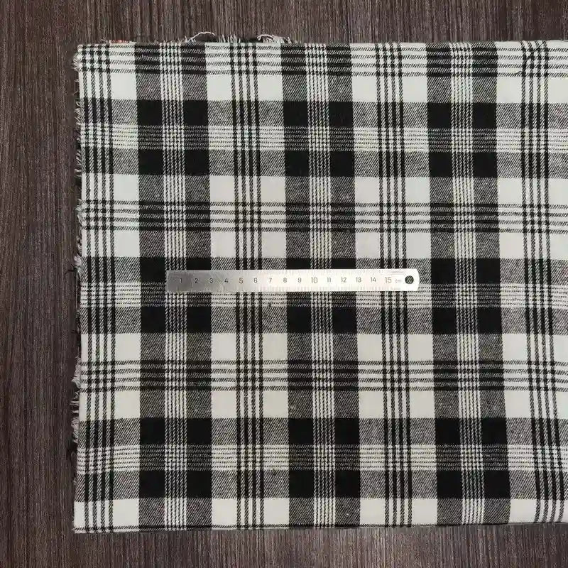 Un tissu en flanelle à carreaux colorés de Longon Craft France, ultra-douillet pour l'automne, est posé sur une surface en bois avec une règle métallique indiquant les centimètres.