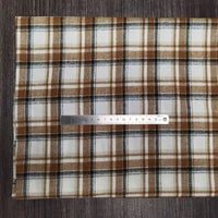 A piece of Tissu en flanelle à carreaux colorés de Longon Craft France is posé à plat sur une surface sombre, avec une règle métallique de 20 cm placée horizontalement pour mesurer la matière ultra-douillette en polyester-coton.