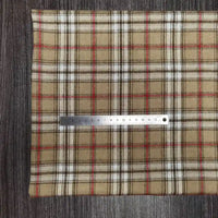 Un morceau de Tissu en flanelle à carreaux colorés Longon Craft France, polyester-coton ultra-douillet, est posé à plat sur du bois foncé avec une règle de 15 cm, parfait pour vêtements d'automne ou hiver.