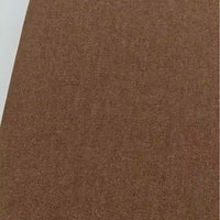 Un gros plan du Tissu jean tissé coloré au mètre de Longan Craft France montre sa surface brune et texturée en denim de coton sergé de 6,5 oz, avec un bord blanc visible dans le coin supérieur gauche - idéal pour les jeans et les projets de tapisserie d'ameublement.