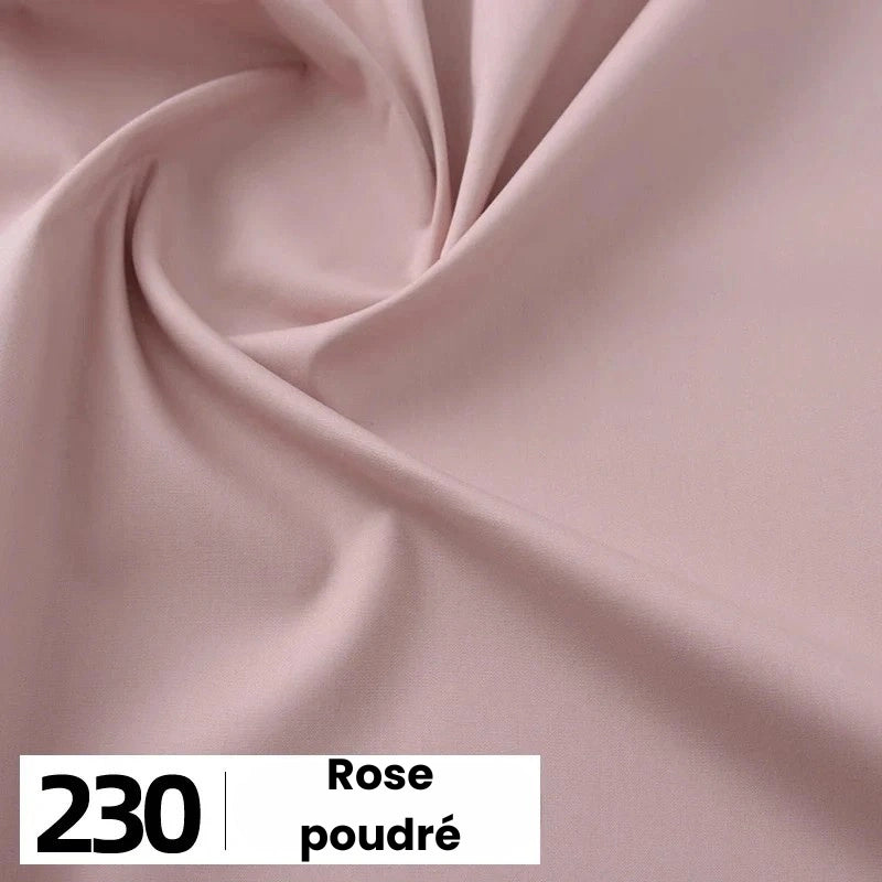 Gros plan sur la popeline de coton rose pâle de Longan Craft France, aux plis délicats. En bas à gauche, une case blanche affiche "230" et le texte "Rose poudré". Idéal pour les chemises, les robes, les doublures. Vendu au mètre.
