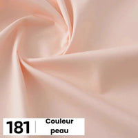 Gros plan sur une popeline de coton beige clair et lisse de Longan Craft France, présentant un subtil motif tourbillonnant et une étiquette 181 "Couleur peau". Idéal pour les chemises, les robes, les doublures ; vendu au mètre.