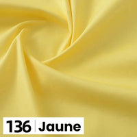 Un gros plan de popeline de coton jaune clair et lisse de Longan Craft France, étiquetée "136 Jaune" en bas à gauche, présente ce tissu doux et léger idéal pour les chemises, les robes, les doublures et d'autres projets de couture.