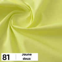 Gros plan sur la popeline de coton jaune pâle et lisse de Longan Craft France. En bas à gauche : étiquette blanche avec "81" et "Jaune doux". Ce tissu léger est parfait pour les chemises, les robes et les doublures.