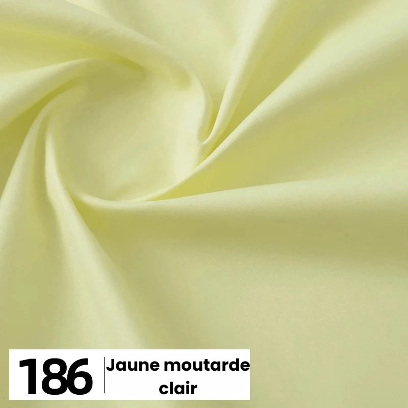 Gros plan sur la popeline de coton au mètre de Longan Craft France en jaune clair ("186 Jaune moutarde clair") avec des plis souples, étiquetée en texte noir gras sur fond blanc dans le coin inférieur gauche.