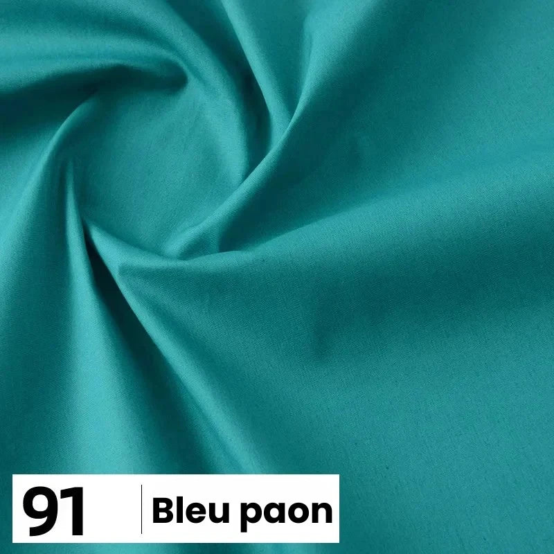 Popeline de coton "Bleu paon" (n° 91) de Longan Craft France, d'une couleur sarcelle profonde, présentée en gros plan avec des plis délicats. Ce tissu doux et léger est parfait pour les chemises, les robes, les doublures et d'autres projets.