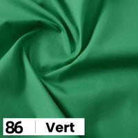 Gros plan sur la popeline de coton au mètre verte de Longan Craft France, un tissu doux et léger pour les chemises, les robes et les doublures. L'image présente un motif tourbillonnant et une étiquette blanche indiquant "86 | Vert" dans le coin inférieur gauche.