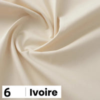Un gros plan de popeline de coton ivoire et lisse de Longan Craft France, étiquetée "6 Ivoire" en bas à gauche, met en valeur ce tissu doux et léger, parfait pour les chemises, les robes et les doublures.