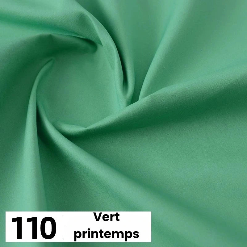 Gros plan sur une popeline de coton vert clair et lisse de Longan Craft France avec de légers plis. En bas à gauche, une case blanche indique "110" et "Vert printemps". Parfait pour les chemises, les robes, les doublures et bien plus encore.