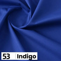 Gros plan sur la popeline de coton au mètre indigo lisse de Longan Craft France, délicatement pliée. En bas à gauche, un encadré blanc indique "53" et "Indigo" en caractères noirs gras. Parfait pour les chemises, les robes, les doublures, etc.