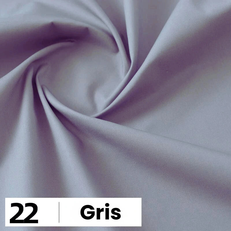 Un morceau lisse de popeline de coton grise de Longan Craft France est torsadé au centre. En bas à gauche, une case blanche indique "22" et "Gris". Parfait pour les chemises, les robes, les doublures ; vendu au mètre comme tissu uni doux et léger.