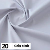 Gros plan sur la Popeline de coton au mètre gris clair de Longan Craft France, disposée en plis souples. Dans le coin, une étiquette indique "20 Gris clair". Cette popeline est légère, douce et parfaite pour les chemises, les robes, les doublures, etc.
