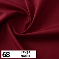 Un gros plan de la popeline de coton rouge foncé et lisse de Longan Craft France montre de légers plis. En bas à gauche, une boîte blanche affiche "68" et "Rouge rouille". Idéal pour les chemises, les robes et les doublures, ce tissu doux est vendu au mètre.