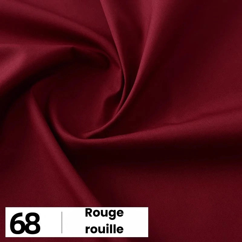 Un gros plan de la popeline de coton rouge foncé et lisse de Longan Craft France montre de légers plis. En bas à gauche, une boîte blanche affiche "68" et "Rouge rouille". Idéal pour les chemises, les robes et les doublures, ce tissu doux est vendu au mètre.