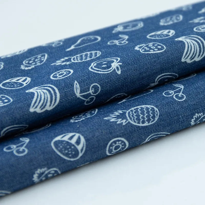 Deux pièces de Tissu denim coton imprimé de fleurs et d'étoiles au mètre de Longan Craft France sont posées sur une surface blanche - parfaite pour coudre des vêtements.