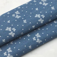 Deux coupons de tissu denim coton léger Longan Craft France, imprimés de fleurs blanches et d'étoiles blanches, parfaits pour vêtements.