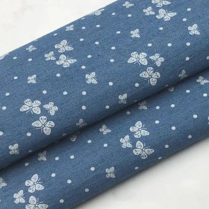 Deux coupons de tissu denim coton léger Longan Craft France, imprimés de fleurs blanches et d'étoiles blanches, parfaits pour vêtements.