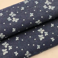 Deux rouleaux de Tissu denim coton imprimé de fleurs et d'étoiles au mètre de Longan Craft France présentent un charmant motif floral et étoilé, ce qui rend ce denim parfait pour des créations vestimentaires stylées et ludiques.