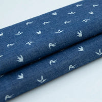 Tissu denim coton imprimé de fleurs et d'étoiles au mètre de Longan Craft France, un denim léger idéal pour vêtements ou projets créatifs grâce à son motif original et sa qualité supérieure.