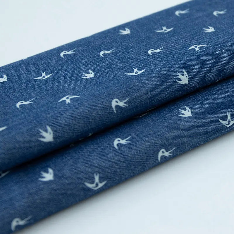 Tissu denim coton imprimé de fleurs et d'étoiles au mètre de Longan Craft France, un denim léger idéal pour vêtements ou projets créatifs grâce à son motif original et sa qualité supérieure.