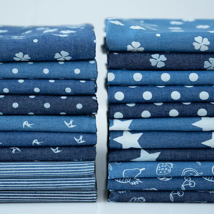Stacks of Longan Craft France tissu denim coton léger imprimé de fleurs et d'étoiles sont alignées sur une surface blanche-idéal pour vos créations vestimentaires. Denim imprimé vendu au mètre.