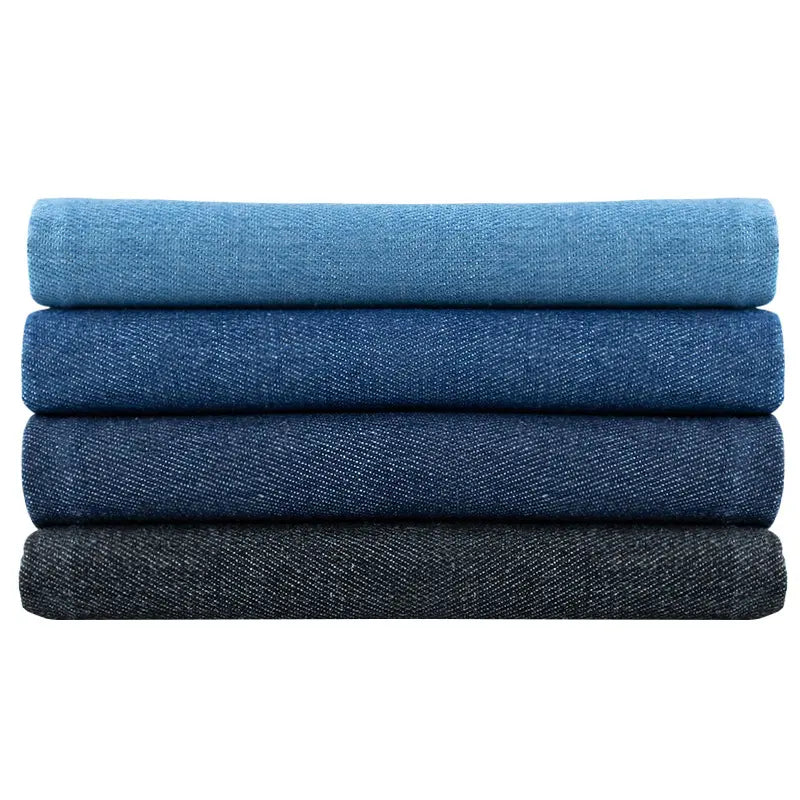 Quatre pièces pliées de Tissu denim délavé 6 oz au mètre par Longan Craft France, disposées en dégradé du bleu clair au bleu foncé et au noir, sont empilées sur un fond blanc. Denim coton doux | Tissu jean bleu.