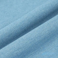 Gros plan sur le Tissu denim délavé 6 oz au mètre de Longan Craft France, un tissu jean en coton doux de couleur bleu clair, à la texture lisse et au tissage visible, présenté avec de légers plis.