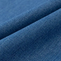 Gros plan sur le Tissu denim délavé 6 oz au mètre de Longan Craft France, un tissu de coton bleu doux avec un tissage visible, de subtiles variations de couleur et de légers plis qui créent des lignes diagonales à travers la texture.