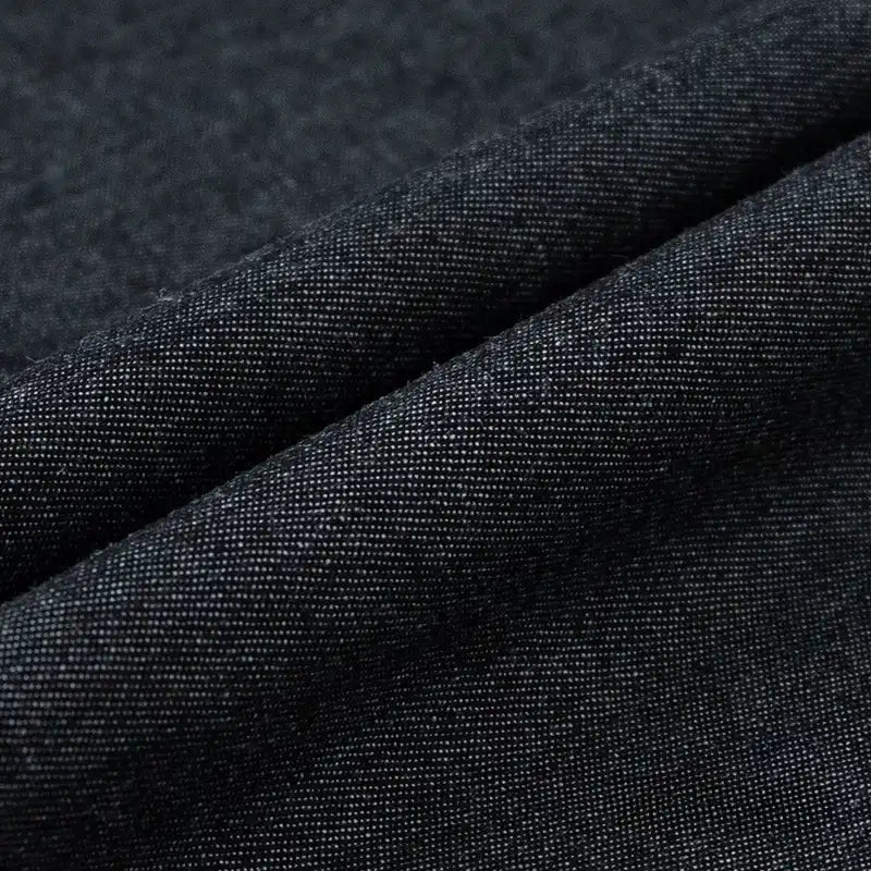 Gros plan sur le Tissu denim délavé 6 oz au mètre de Longan Craft France, un tissu jean bleu doux à la texture fine et lisse et au motif de tissage visible pour une finition mate raffinée.