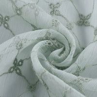 Gros plan sur le Tissu voile froissé au mètre de Longan Craft France : voile de polyester vert clair avec broderie florale vintage, délicate et fluide - idéal pour les vêtements d'été ou les rideaux.