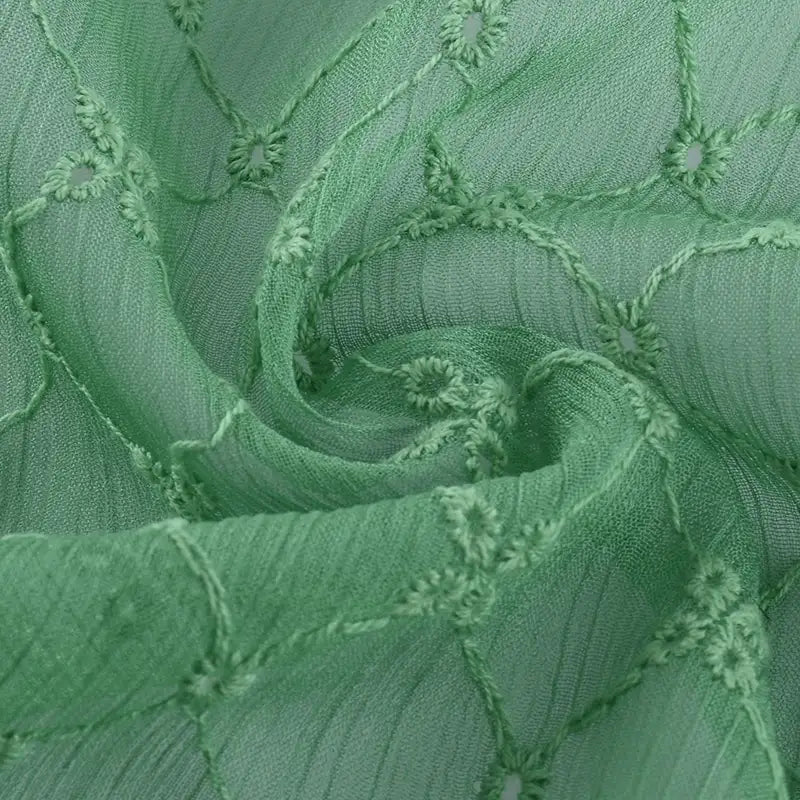 Gros plan sur le "Tissu voile froissé au mètre" de Longan Craft France : voile de polyester vert clair, légèrement froissé, brodé de motifs floraux vintage - idéal pour confectionner des vêtements ou des rideaux aérés.