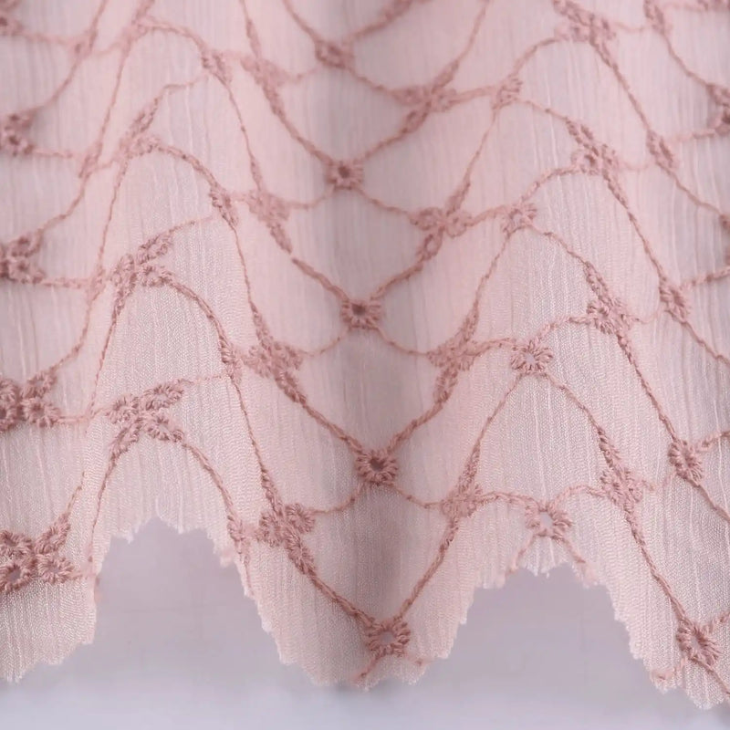 Gros plan sur le Tissu voile froissé au mètre de Longan Craft France : polyester brodé à motifs floraux vintage, légèrement transparent, parfait pour vêtements légers ou rideaux d'été.
