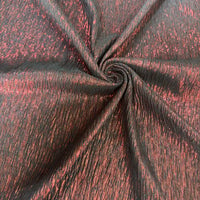 Gros plan sur le tissu lamé froissé au mètre de Longan Craft France, composé de polyester métallisé noir et rouge à la texture froissée et à la finition mate et brillante - un tissu parfait pour les costumes, les robes et la couture.