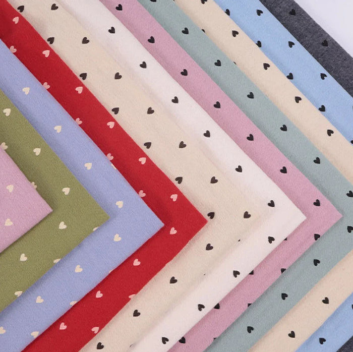 Les échantillons diagonaux de Flanelle de coton à motifs cœurs au mètre de Longon Craft France affichent des motifs de cœurs noirs et blancs. Ce tissu flanelle doux et confortable est idéal pour les pyjamas, le quilting et les projets de couture créatifs.