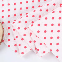 Le Seersucker à pois au mètre de Longan Craft France est un seersucker de coton blanc léger et aéré, à pois rouges et aux bords soigneusement pliés, parfait pour les costumes vintage et les projets de couture créatifs.