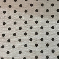 Un gros plan du Seersucker à pois au mètre de Longan Craft France montre un seersucker de coton blanc avec de petits pois noirs dans une grille régulière ; la texture du tissu vintage léger est légèrement visible.