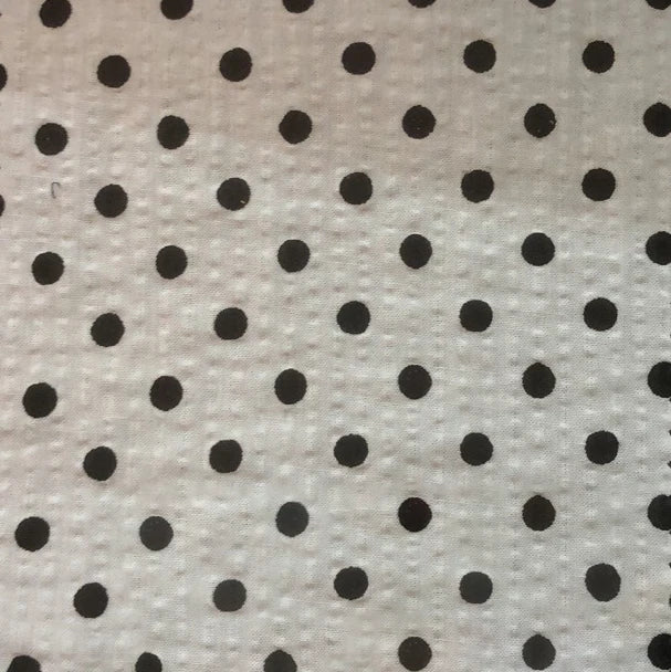 Un gros plan du Seersucker à pois au mètre de Longan Craft France montre un seersucker de coton blanc avec de petits pois noirs dans une grille régulière ; la texture du tissu vintage léger est légèrement visible.