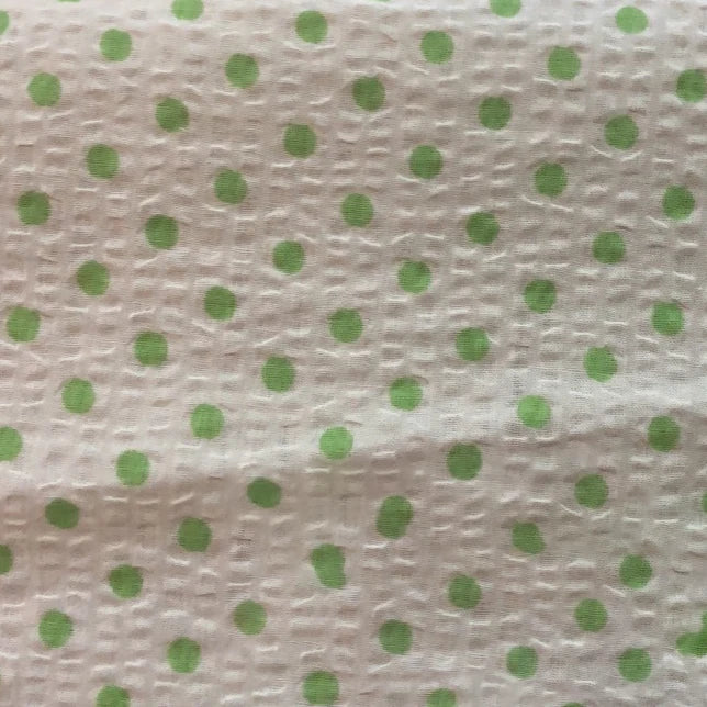 Gros plan sur le Seersucker à pois au mètre de Longan Craft France, un tissu de coton seersucker blanc à pois verts régulièrement espacés et à la texture froissée unique, parfait pour les costumes vintage.