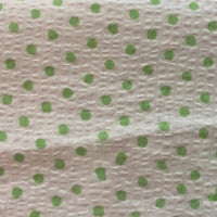Gros plan sur le Seersucker à pois au mètre de Longan Craft France, un tissu de coton seersucker blanc à pois verts régulièrement espacés et à la texture froissée unique, parfait pour les costumes vintage.