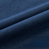 Un gros plan du tissu en jean extensible au mètre de Longan Craft France met en évidence sa texture tissée et ses plis diagonaux, parfaits pour créer des vêtements et des jeans confortables.
