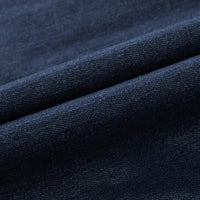 Gros plan sur le Tissu en jean extensible au mètre de Longan Craft France, un tissu denim extensible bleu foncé de 8 oz pour vêtements et jeans, montrant son motif de tissage visible et deux plis parallèles diagonaux.