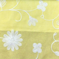 Le Tissu brodé floral en gaze de lin au mètre de Longan Craft France est un tissu de lin naturel et transparent avec des fleurs blanches brodées et des vignes tourbillonnantes - idéal pour les robes d'été ou les vêtements de bébé.