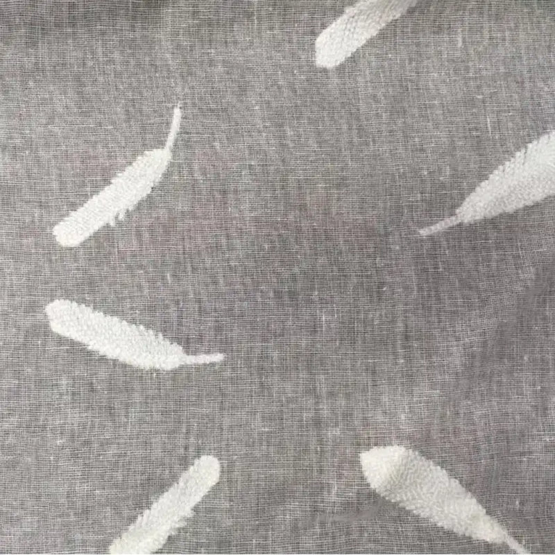 Gros plan sur le "Tissu brodé floral en gaze de lin au mètre" de Longan Craft France - un tissu en lin naturel et transparent, avec des motifs de plumes blanches dispersés dans différentes directions. Parfait pour les vêtements et les accessoires.
