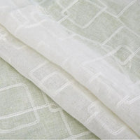 Gros plan sur le Tissu brodé floral en gaze de lin au mètre de Longan Craft France, qui présente de délicats motifs floraux brodés et met en valeur la texture naturelle et transparente du lin, idéale pour l'habillement.