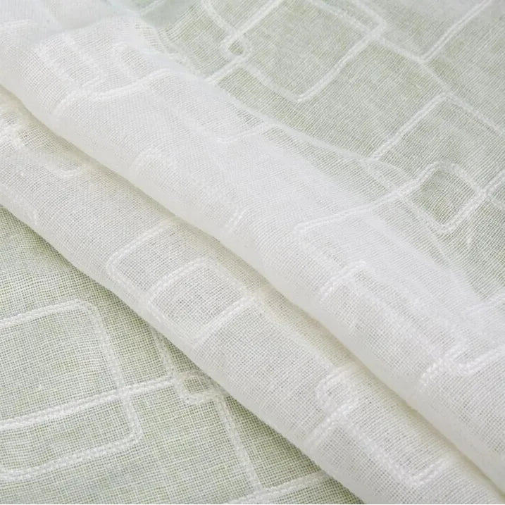 Gros plan sur le Tissu brodé floral en gaze de lin au mètre de Longan Craft France, qui présente de délicats motifs floraux brodés et met en valeur la texture naturelle et transparente du lin, idéale pour l'habillement.