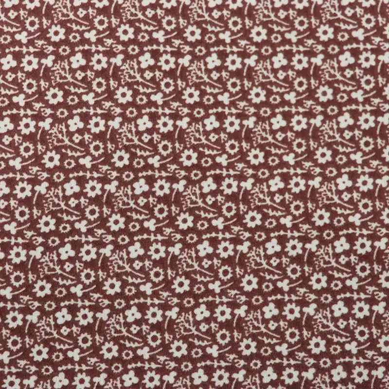 Flanelle de coton fleurie au mètre Longan Craft France : tissu imprimé coloré d'automne à motifs floraux blancs sur fond bordeaux, idéal pour la couture de robes, vêtements et loisirs créatifs.