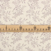 Une règle en bois (3-21 cm) est posée sur la Flanelle de coton fleurie au mètre de Longan Craft France, une flanelle de couleur crème avec un motif floral gris clair, idéale pour les vêtements d'hiver, la couture et les projets créatifs.